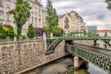 Obraz premium Vienna, Austria - July 23, 2024: The historic Zollamtsbrücke rail and footbridges crossing the Wienfluss canal in the early morning in Vienna 