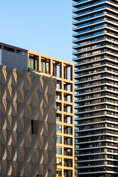 Fototapeta A scene capturing high-rise buildings bathed in golden sunlight with a mix of textures, from sleek glass to textured designs, embodying urban beauty and magnificence.