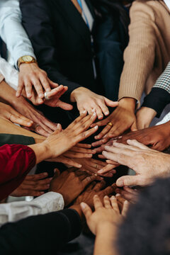 Multiethnic teamwork showing unity with diverse hands working together in a group environment to achieve a common goal