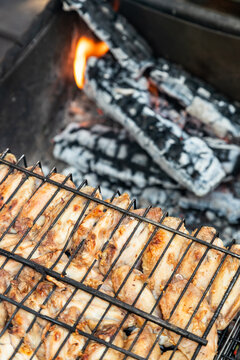 Chiken on the grill against the background of hot coals in the grill - paleo food photography.Delicious chiken steak, hot barbecue grill.Roasted chiken leg Grilled, BBQ. Barbecue, picnic in nature