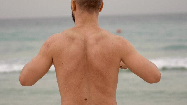 man treating posture on the seashore, back pain training
