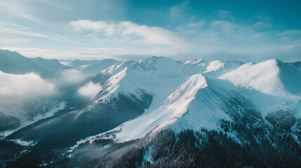 Stunning aerial view of a snow-covered mountain range under a clear blue sky during winter