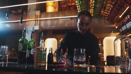 Portrait good looking Asian bartender using jigger measure liquor syrup into mixing glass preparation at luxurious beverage counter bar, neat professional barman costume at nightclub luxury. Vinosity.