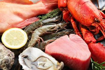 Whole fresh raw lobster and other sea food as background, closeup