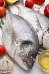 Sea food. Fresh raw fish and products on white tiled table, closeup