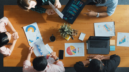 Top view of project manager using tablet to analyze data and financial chart while marketing team...