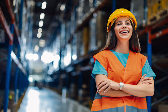 Female warehouse worker smiling with arms crossed