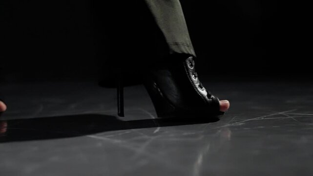 Dancer wearing high heels is performing a dance routine on a stage. Her graceful movements are captured in a series of still frames