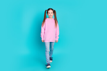 Full body photo of cute little girl walking dressed stylish pink clothes isolated on aquamarine color background