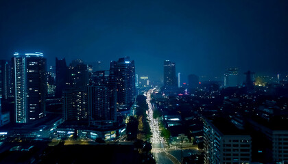 Naklejka premium Aerial shot of city skyline at night with traffic at streets, fog and rainy weather