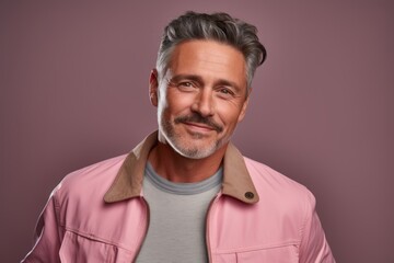 Obraz premium Portrait of a blissful man in his 50s wearing a trendy bomber jacket while standing against pastel or soft colors background
