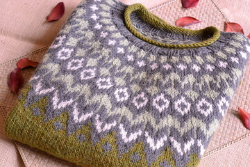 Lopapeysa nordic icelandic sweater hand knitted wool winter warm handmade organic cloth, green color, sustainable ecological living concept, traditional jacquard pattern 