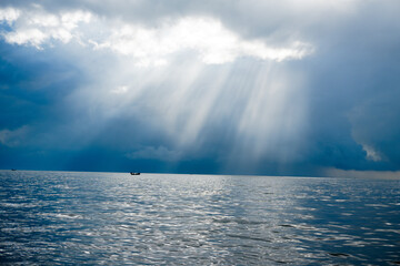 Misty morning over the endless ocean, with wispy clouds dancing across the blue sky as the sun begins its ascent, casting a golden glow on the calm waters