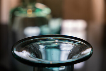 Artistic and abstract composition with the close-up of an old vintage big blue glass bottle. The natural light illuminates and produces shine and beautiful and creative shapes. creative background