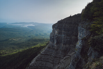sheer cliff above a valley in the mountains, view of a mountain lake, steep cliff