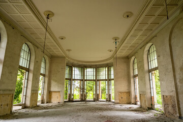 Abandoned hall with large floor-to-ceiling windows