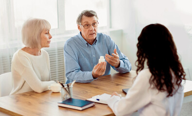 Treatment Concept. Senior man discussing prescription medicine with female caretaker at hospital, copyspace