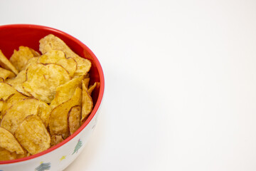 A bowl of crisps or chips in a Christmas bowl on a white background