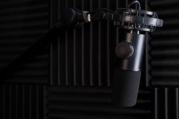 Microphone for studio sound recording. Studio. High-quality sound. Soundproofing. Black microphone. Studio microphone. Podcast. Radio. Minimalistic design. Dark background. Carbon body