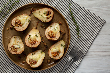 Homemade Blue Cheese Stuffed Pears with Honey, Thyme and Walnuts on a Plate, top view.