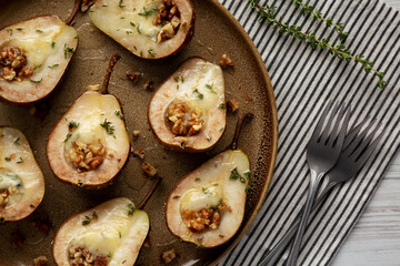 Homemade Blue Cheese Stuffed Pears with Honey, Thyme and Walnuts on a Plate, top view. Close-up.