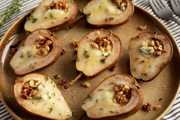 Homemade Blue Cheese Stuffed Pears with Honey, Thyme and Walnuts on a Plate, side view.