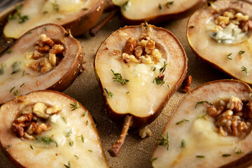 Homemade Blue Cheese Stuffed Pears with Honey, Thyme and Walnuts on a Plate, side view. Close-up.
