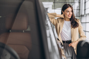 Woman, portrait and smile at car dealership with sale, payment and purchase of new motor. Shopping, customer with pride from deal and investment of vehicle at showroom and store