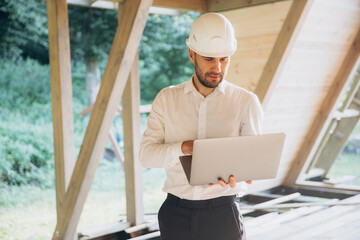 Man builder. Foreman with laptop. Contractor for construction company. Architect in unfinished...