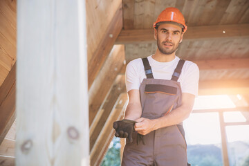 Process of construction new and modern modular house. Worker man in special protective uniform puts...