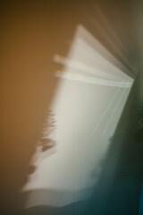 Light casts abstract shapes on a wall