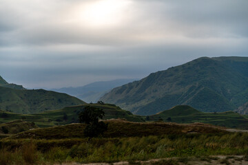 Fototapeta premium A mountain range with a cloudy sky in the background