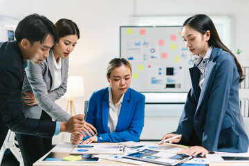 Team of asian businesspeople are having a meeting analyzing financial documents at a table in a modern office