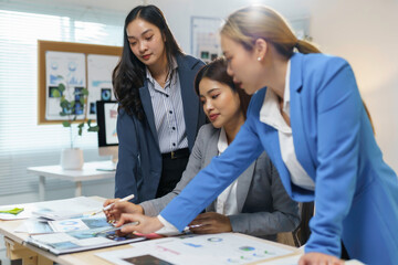 Team of businesswomen is working together on a project, analyzing data and developing a plan