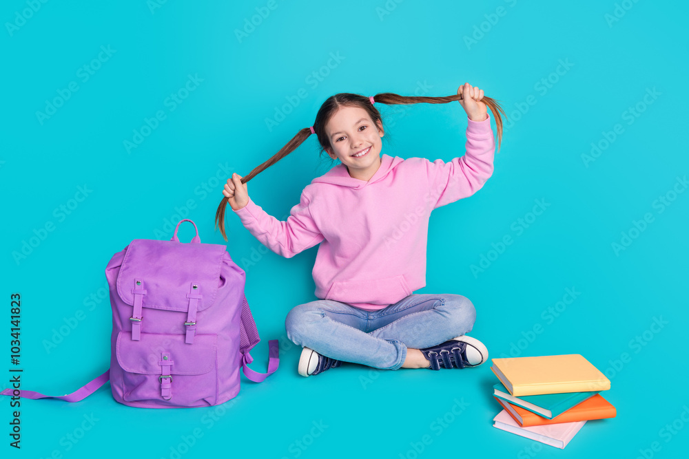 Wall mural Full size photo of pretty little girl pull tails sit floor school sales wear trendy pink outfit isolated on aquamarine color background