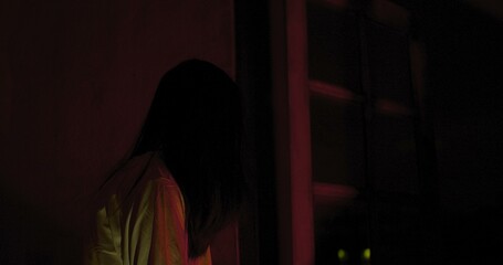 Horror scene of a mysterious Scary Asian ghost woman creepy looking to camera with dark scene movie...