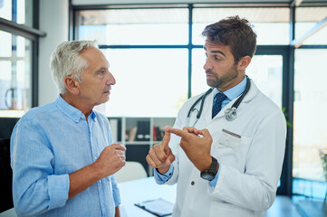 Senior man, doctor and consulting with patient for medical dosage, prescription or side effects at clinic. Mature, male person and healthcare professional explaining for health advice or consultation