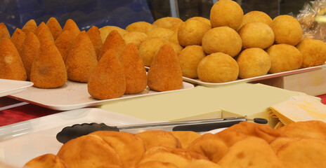 many meatballs made with rice and ham and cheese called ARANCINI or ARANCINE typical dish of the island of Sicily in Southern Italy sold at the stall