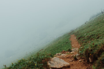 Misty mountain hiking trail with dirt path 