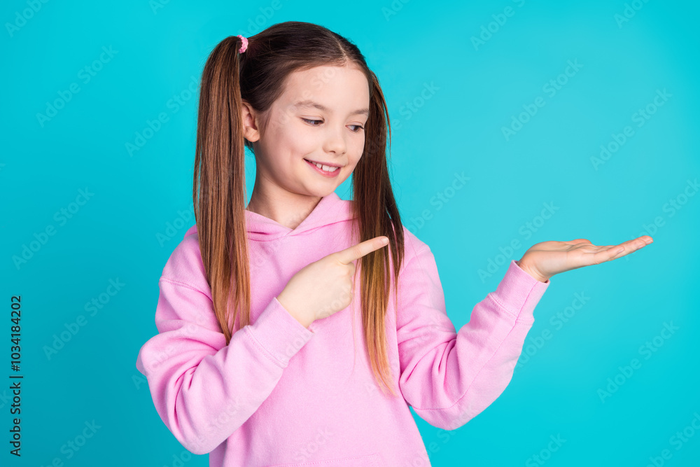 Sticker Photo portrait of cute little girl look point hold empty space dressed stylish pink clothes isolated on aquamarine color background