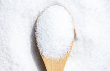 Salt in a wooden spoon close-up.
