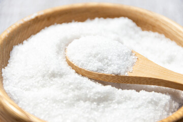 Salt in a wooden spoon close-up.