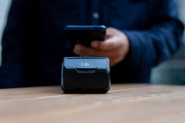 Customer using smartphone to make contactless payment in a cafe