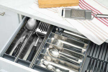 Box with cutlery in drawer, closeup. Kitchen utensils storage