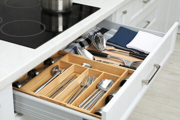 Box with cutlery in drawer, closeup. Kitchen utensils storage