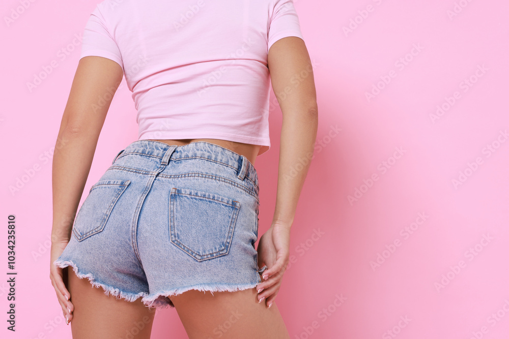 Poster Woman wearing stylish denim shorts on pink background, closeup. Space for text