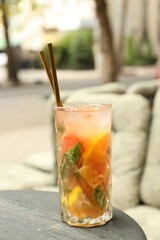 Glass of tasty refreshing drink and straws on table