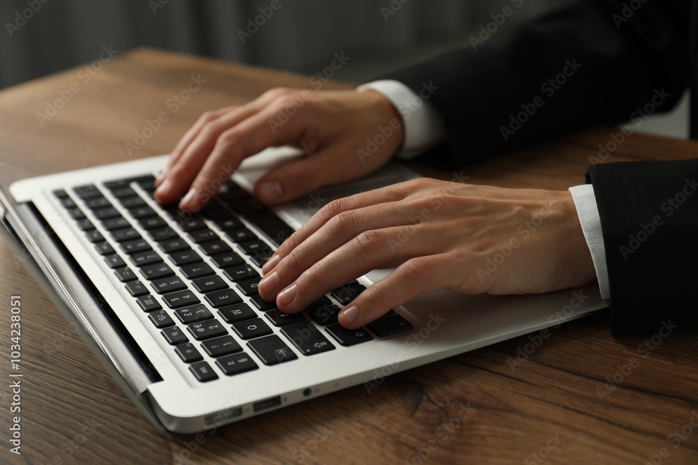 Wall mural businesswoman using laptop at wooden table indoors, closeup. modern technology