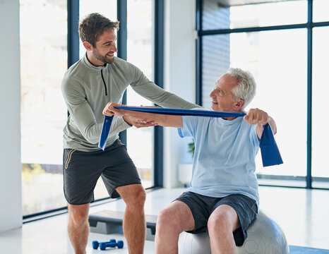 Fitness, old man or physiotherapist with exercise band for stretching, wellness or healing for injury. Rehabilitation, senior patient or male person with help for physiotherapy, arms recovery or ball