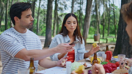 People relaxing forest picnic eating at table sunny day closeup. Smiling woman